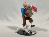 figurine of a man with a stack of books and a dog