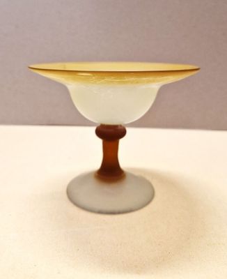 a small glass bowl with a wooden base on a table