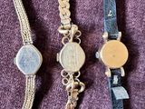 three different types of wrist watches on a purple cloth