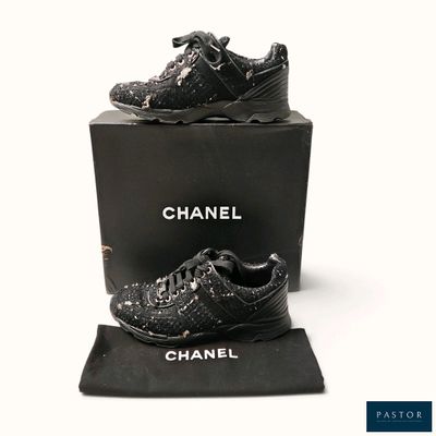 baskets Chanel en cuir noir ornées de clous argentés, présentées dans un coffret noir