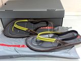 une paire de tongs pour homme dans une boîte, accompagnée d'une paire de lunettes de soleil
