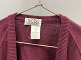 un gros plan d'un pull violet suspendu à un cintre