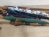 Plusieurs parapluies sont alignés sur une table en bois dans une pièce