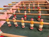 a foosball table that has many wooden toys on it
