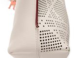 a close up of a white purse with holes on it