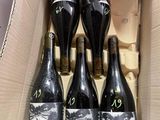 six bottles of wine in a cardboard box on a table