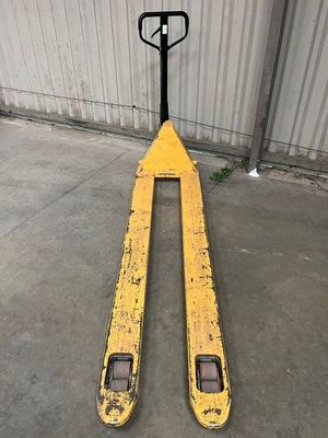 Le chariot élévateur est garé devant un bâtiment sur lequel est accrochée une pancarte.