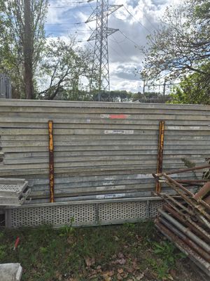 un tas de bois posé par terre à côté d'une clôture
