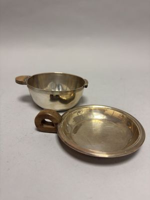 une paire de bols et de cuillères plaqués argent posés sur un fond blanc