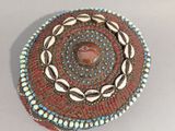 une photo d'une broche ornée de coquillages et de perles