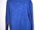 a blue sweater on a mannequin stand against a white wall