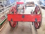 a red wagon that is sitting in the middle of a barn