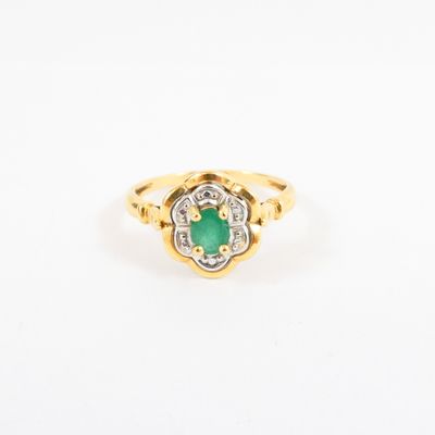 a gold ring with an emerald stone and diamonds