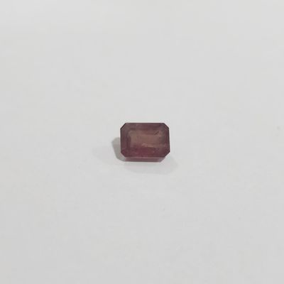 a square shaped red ruby stone on a white surface
