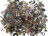 a pile of assorted jewelry on a white surface