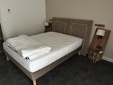 a bed with a white blanket on it in a room