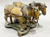 two horses pulling a cart with a man on it