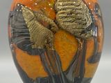 a vase with a gold leaf decoration on it