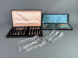 four forks and a knife in a case on a table