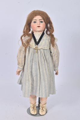 an old doll with long hair wearing a dress and shoes