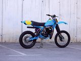 a blue dirt bike parked in a parking lot