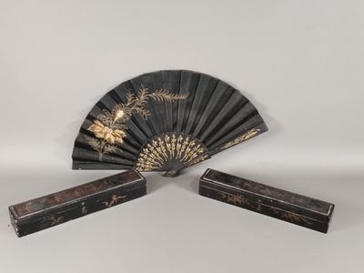 une paire d'éventails noirs et dorés, ornés de motifs dorés