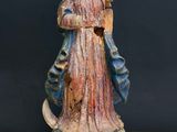 an old statue of a woman holding a bird on a table