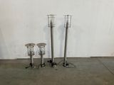 three metal candles that are sitting on the floor