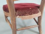 a wooden chair with a red cushion on it