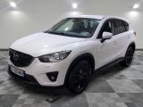 La Mazda CX-5 blanche est garée sur un sol à damier.