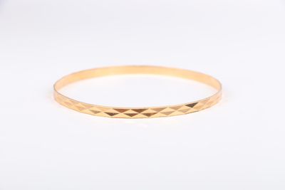 gros plan d'une bague en or sur une surface blanche