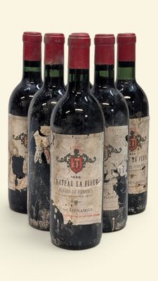 quatre bouteilles de vin sont alignées sur une surface blanche