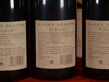 three bottles of wine sitting on top of a wooden table