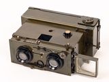 an old camera that is sitting on a white surface