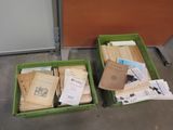 two green bins filled with books sitting on top of a cement floor
