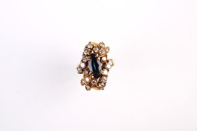 gros plan d'une bague avec une pierre bleue entourée de diamants