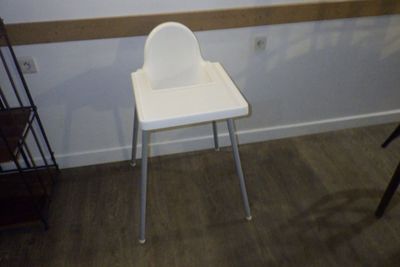 une chaise haute blanche dans une pièce dotée d'une fenêtre