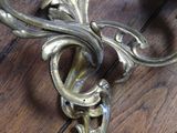 a metal wall mounted candle holder on a wooden floor
