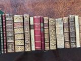 many books that are stacked on a shelf