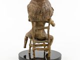 statue of a woman sitting in a chair with a dog on her lap