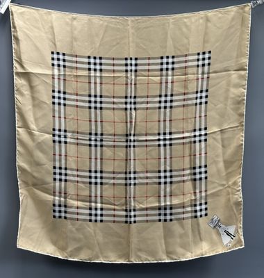 a beige scarf hanging from a clothes line on a clothes line
