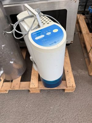 a water purifier sitting on a pallet next to a microwave