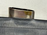 a silver ring sitting on top of a black purse