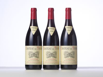 three bottles of red wine sitting on top of a table