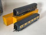 two train cars sitting next to each other on a table