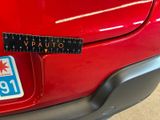 a close up of a red car with a ruler on it ' s bumper