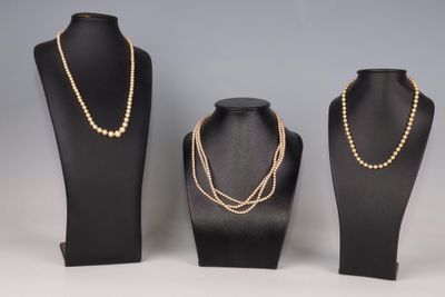 trois mannequins noirs ornés de chaînes en or et de perles
