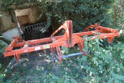 une charrue tractée qui est abandonnée dans les buissons