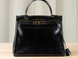 a black leather handbag sitting on top of a wooden table