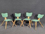 trois chaises vertes placées les unes à côté des autres sur une surface grise